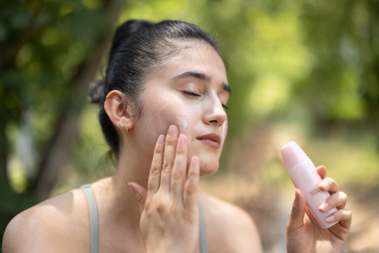 Woman apply sunscreen lotion before outdoor workout